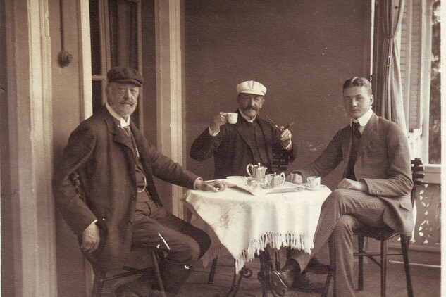 Historická fotografie tří mužů sedících u stolu při odpoledním čaji. | © Archiv SZ Vizovice